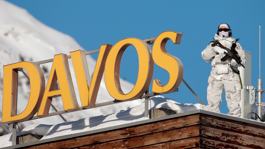 An armed member of the Swiss police watches from the snow-covered roof of the Hotel Davos ahead of the World Economic Forum (WEF) in Davos, Switzerland, on Monday, Jan. 20, 2020. 