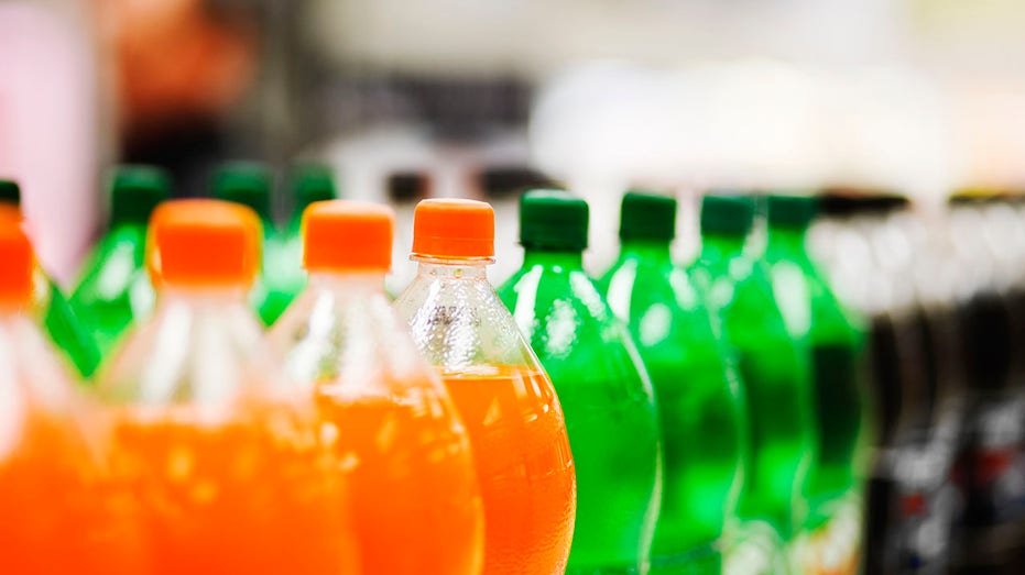 Lots of soda bottles in various flavors all lined up