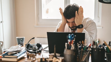 Tired frustrated exhausted businessman working from home online sitting at home office with laptop during quarantine and self isolation period at pandemic. Crisis management. Despair of market falling down. - Fox Business News