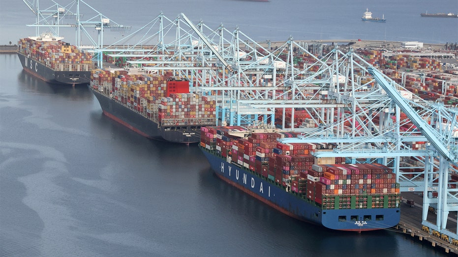 Shipping containers are unloaded from ships at a container terminal at the Port of Long Beach-Port of Los Angeles complex in Los Angeles, April 7, 2021. 