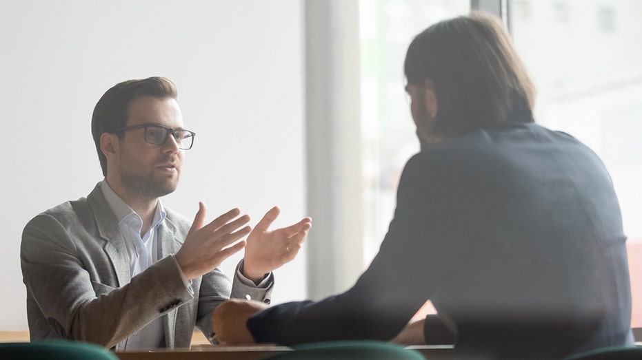 Two individuals having a conversation in an office