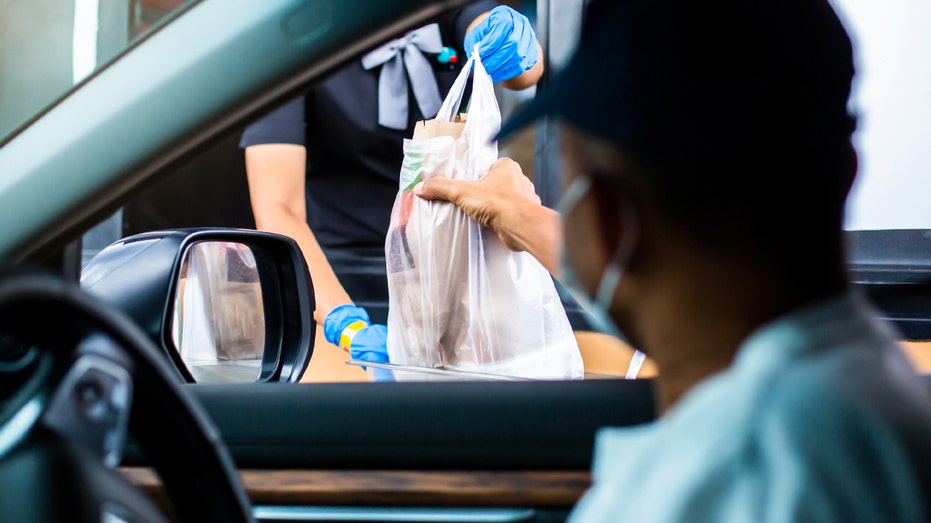 Drive-thru window showing someone handing off a bag