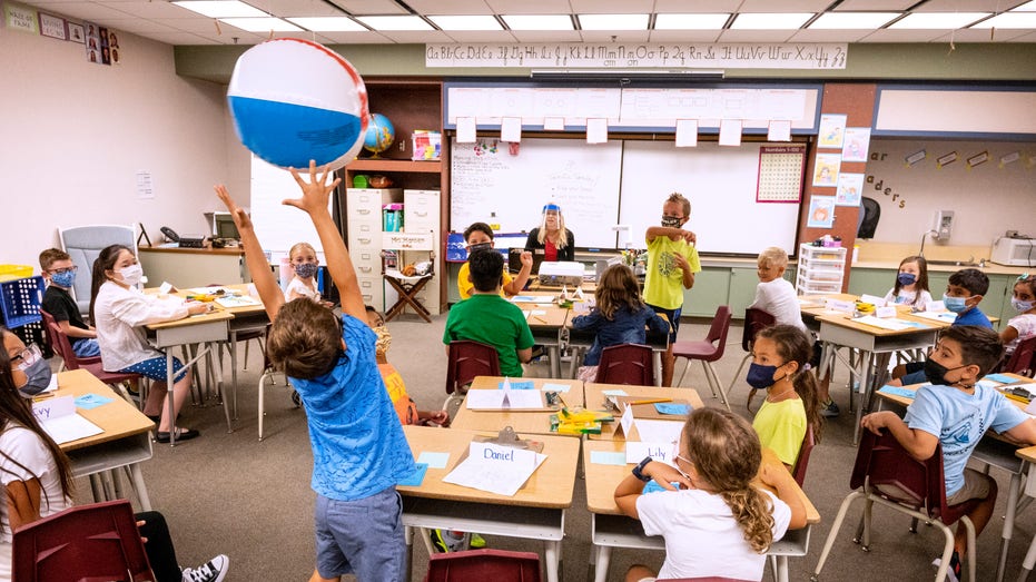 Kids playing with a beachball in class