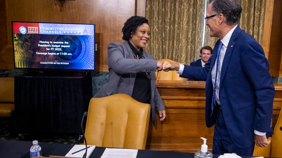 Acting Director of the Office of Management and Budget Shalanda Young fist bumps Sen. Mitt Romney, R-Utah, prior to a Senate Budget Committee hearing June 8, 2021 on Capitol Hill in Washington, D.C.