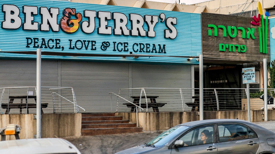 A man walks past a closed "Ben & Jerry's" ice-cream shop in the Israeli city of Yavne, about 30 kilometres south of Tel Aviv, on July 23, 2021. (Photo by AHMAD GHARABLI/AFP via Getty Images)