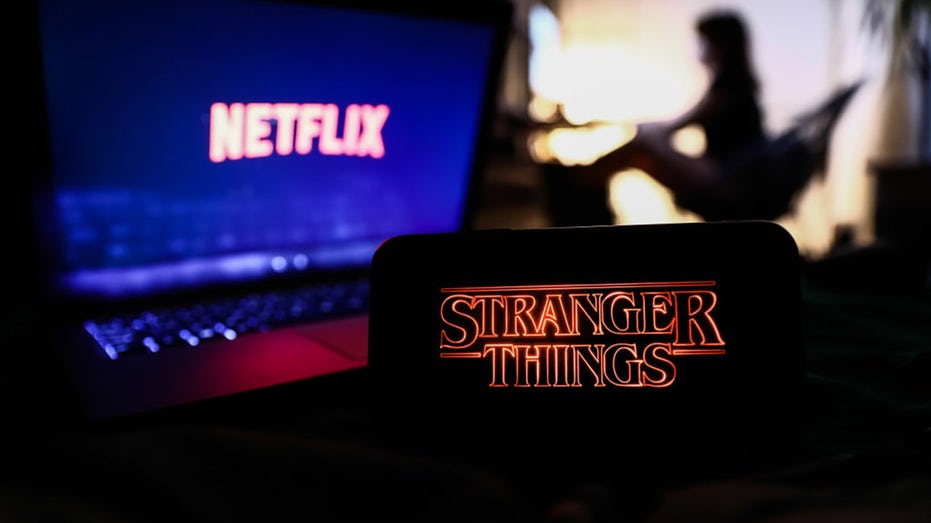 Netflix's "Stranger Things" logo and a woman in the background