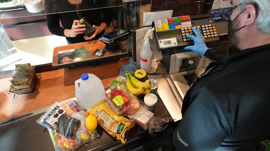 A cashier assists a customer at a checkout counter at Harmons Grocery store in Salt Lake City, Utah, U.S., on Thursday, Oct. 21, 2021. More than a year and a half after the coronavirus pandemic upended daily life, the supply of basic goods at U.S. grocery stores and restaurants is once again falling victim to intermittent shortages and delays. Photographer: George Frey/Bloomberg