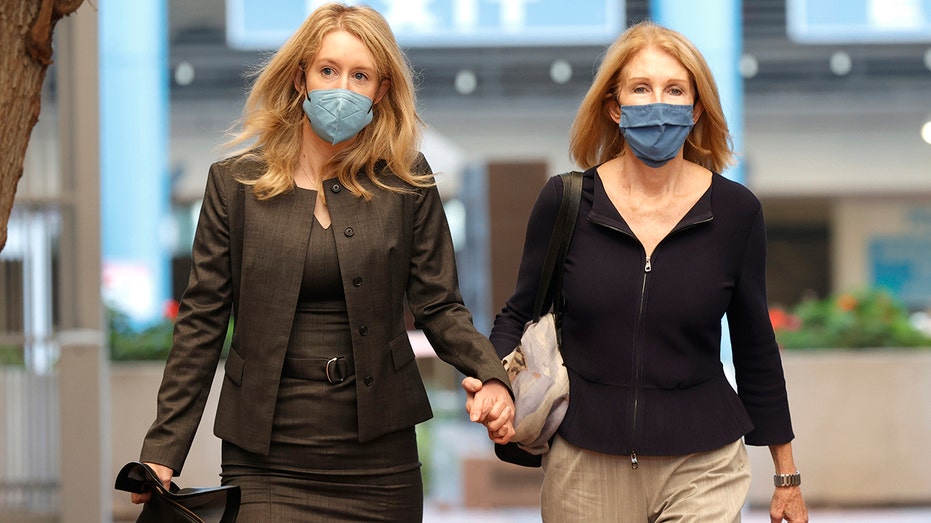 Theranos founder and former CEO Elizabeth Holmes (left) walks with her mother, Noel Holmes, as they arrive for Elizabeth Holmes' trial at the Robert F. Peckham Federal Building on Nov. 17, 2021, in San Jose, California. 