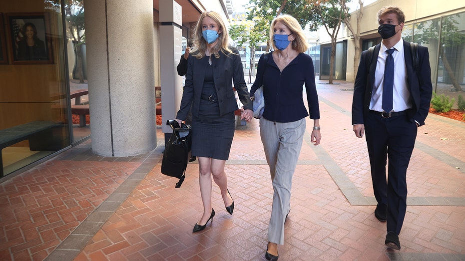 Theranos founder and former CEO Elizabeth Holmes (L) walks with her mother, Noel Holmes, as they arrive for Elizabeth Holmes' trial at the Robert F. Peckham Federal Building on Nov. 17, 2021, in San Jose, California.