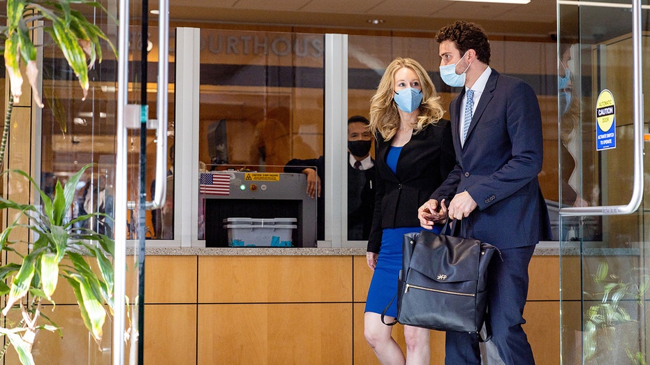 Theranos founder and former CEO Elizabeth Holmes along with her partner Billy Evans (R) depart the Robert F. Peckham Federal Building on Nov. 22, 2021, in San Jose, California.