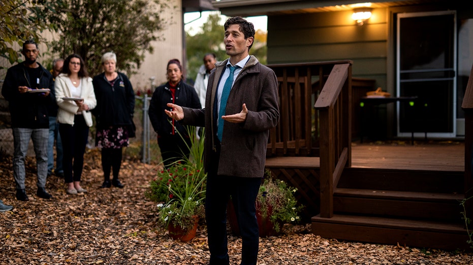 Jacob Frey speaking to people in a backyard