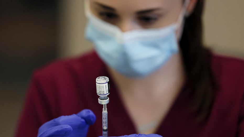 nurse drawing a COVID vaccine 