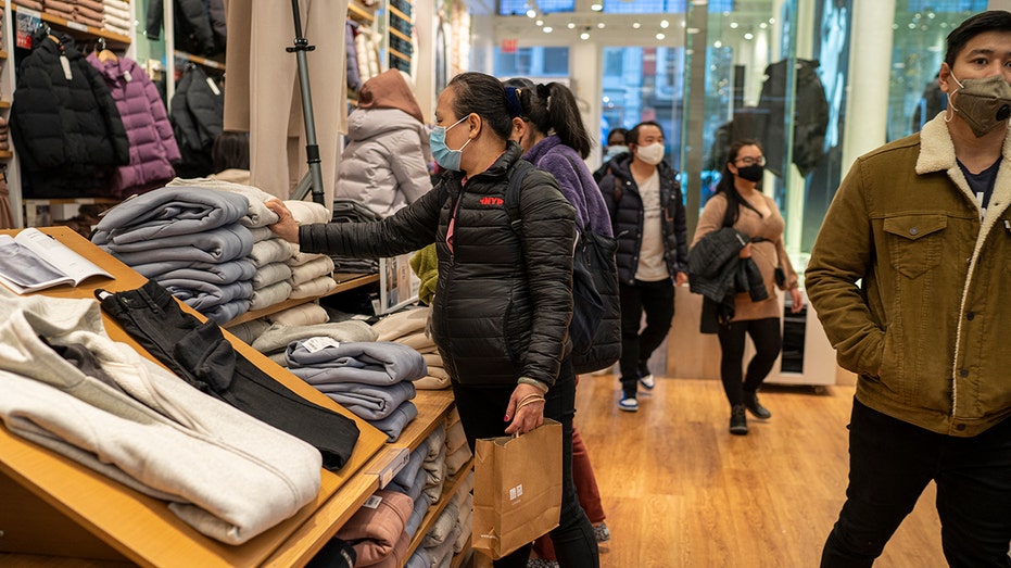 Shoppers search for clothing at Uniqlo Retail Clothing Company Nov. 12, 2021, in New York City. 