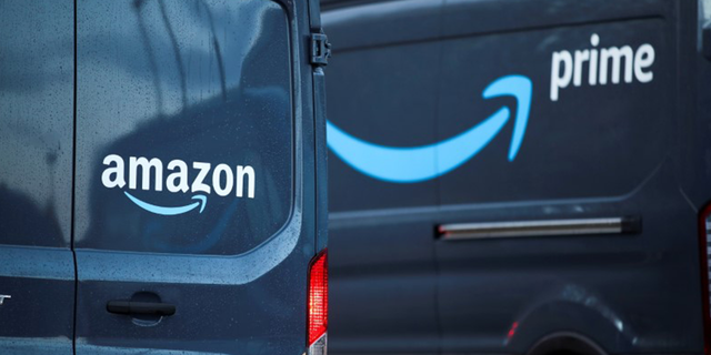 FILE PHOTO: Amazon and Amazon Prime logos are pictured on vehicles outside Amazon's fulfillment center in Altrincham, near Manchester, Britain November 26, 2021. REUTERS/Carl Recine/File Photo 