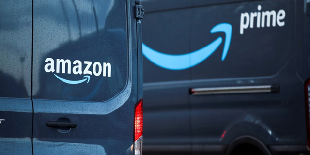 FILE PHOTO: Logos of Amazon and Amazon Prime are pictured on vehicles outside the Amazon Fulfilment Centre in Altrincham, near Manchester, Britain, November 26, 2021. REUTERS/Carl Recine/File Photo 