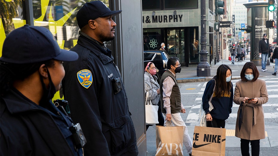 San Francisco Police officers stand guard outside the Nike store while shoppers search for Black Friday deals at Union Square in San Francisco, California, Friday, Nov. 26, 2021. 