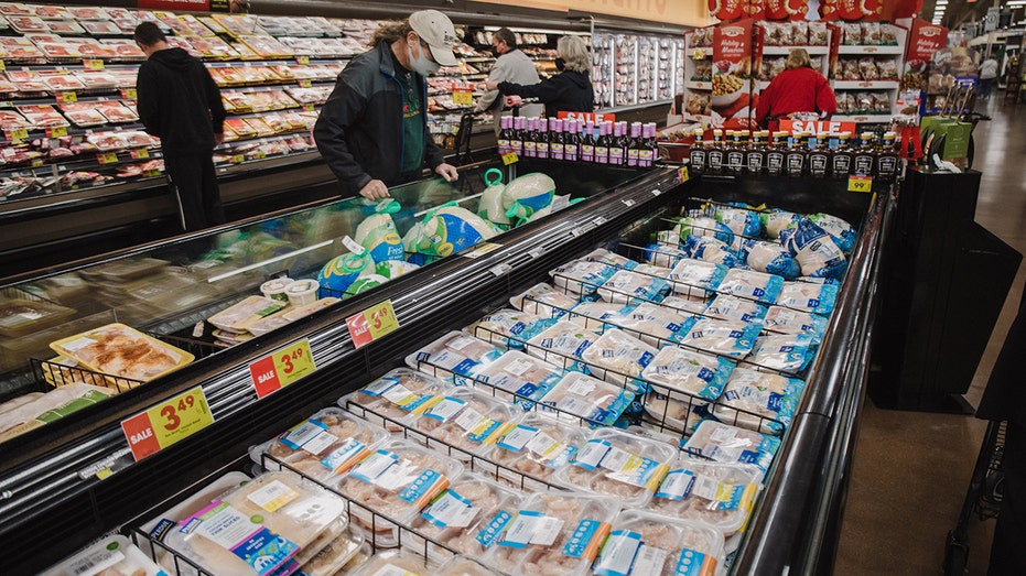 Customers shop in the meat section