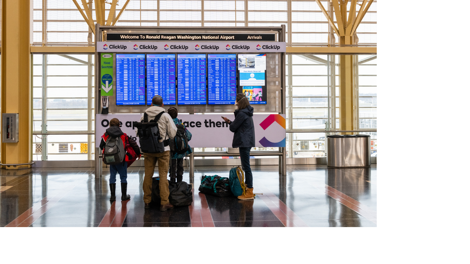 A family looks at flight information at Reagan National Airport in Arlington, Virginia, on Friday, Dec. 24, 2021. 