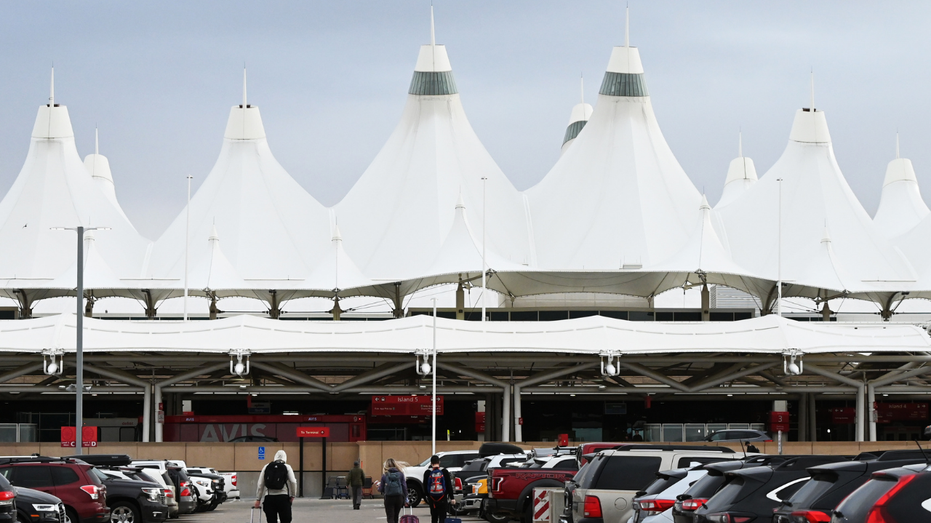 Travelers make their way into Denver International Airport.