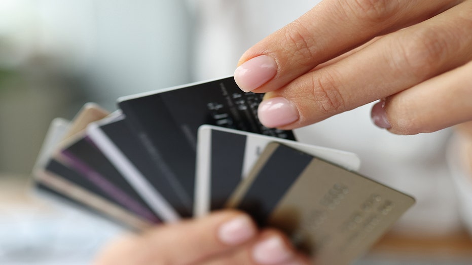 A fan of plastic credit cards in a woman's hand. 