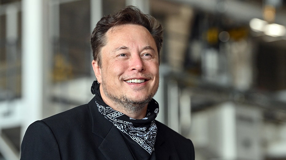Tesla CEO Elon Musk smiling while at one of his factories