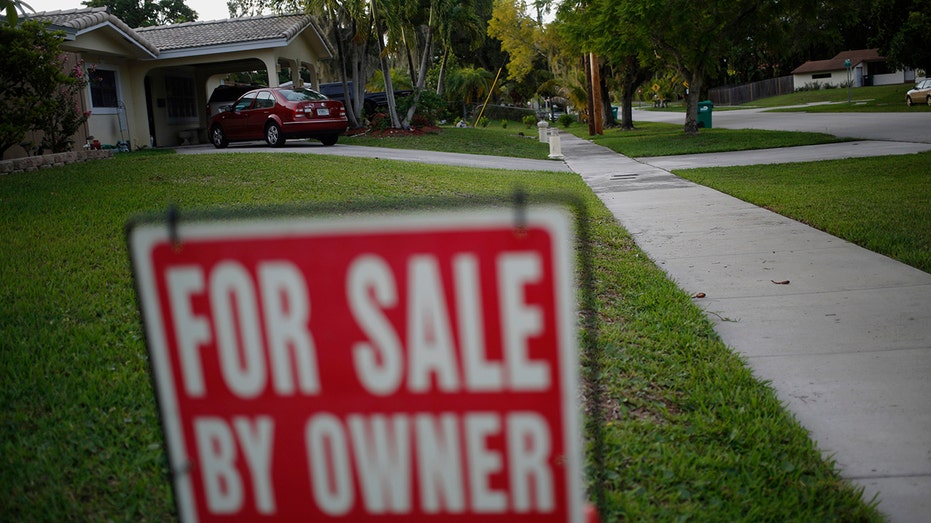 A "For Sale By Owner" sign stands in front of a house in Miami, Florida, on Monday, June 15, 2015.