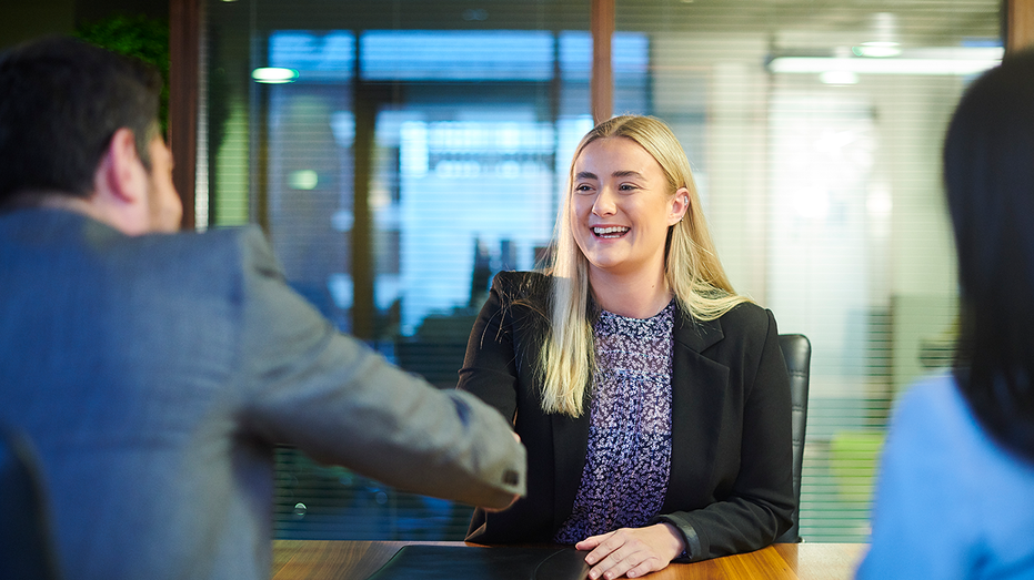 Woman shakes hands at job interview