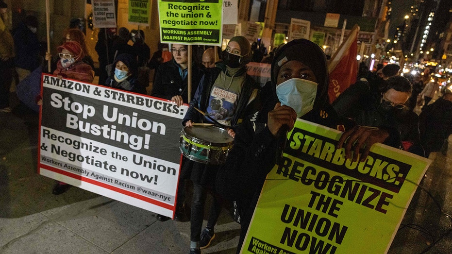 People march during a protest in support of Amazon and Starbucks workers in New York City on Nov. 26, 2021. 