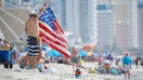 MYRTLE BEACH, SC - MAY 29:A beachgoer spreads out a patriotic towel on May 29, 2021 in Myrtle Beach, South Carolina. Myrtle Beach is the No. 3 top destination for road trips on Memorial Day, according to AAA Carolinas. (Photo by Sean Rayford/Getty Images)