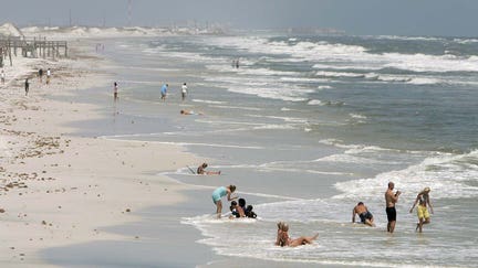 Visitors return to the Destin Florida beach July 11, 2005, one day after Hurricane Dennis struck the area. Relief crews fanned out over northwest Florida on Monday to gauge the misery and debris strewn anew by Hurricane Dennis on a region still recovering from a devastating hurricane last year. REUTERS/ Mark Wallheiser  MW/TC
