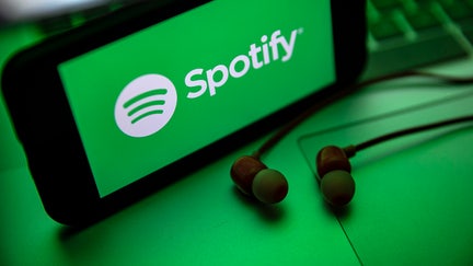 TURKEY - 2021/12/02: In this photo illustration the Spotify logo seen displayed on a smartphone screen near a pair of earphones. (Photo Illustration by Onur Dogman/SOPA Images/LightRocket via Getty Images)