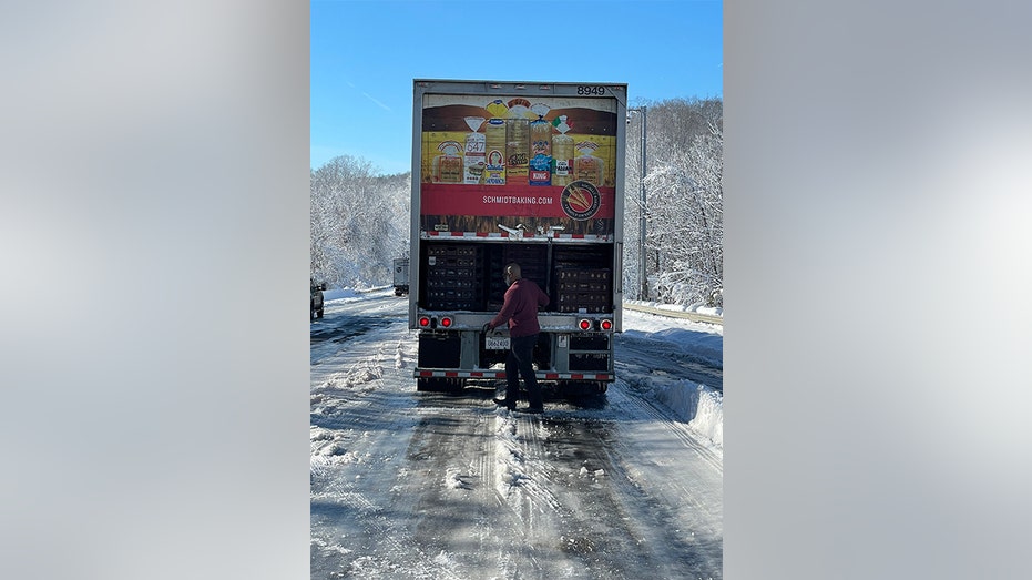 Bread truck driver opening up the back of the truck to pass out bread on I-95. 