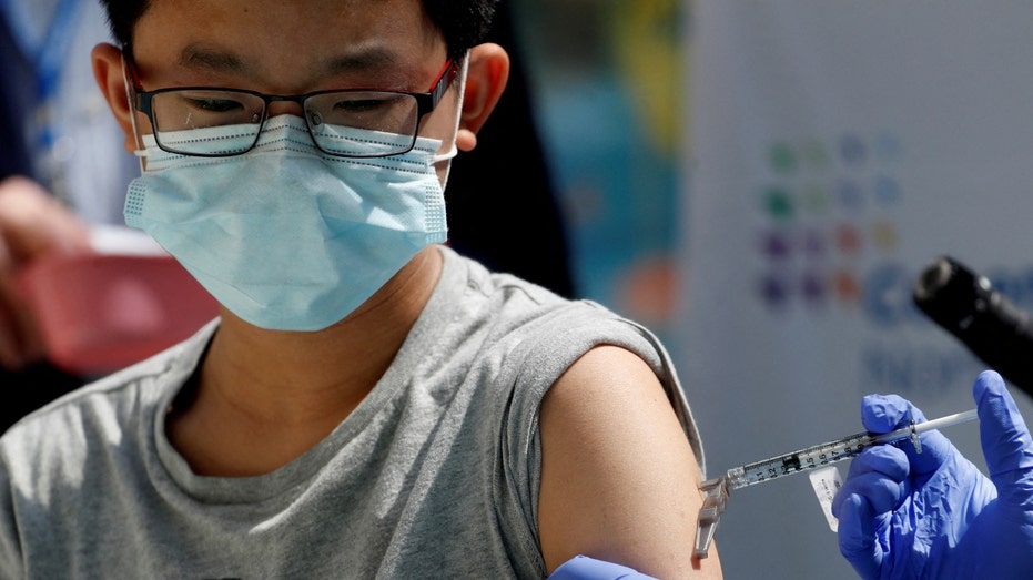 A 13-year-old boy receives a dose of the Pfizer vaccine