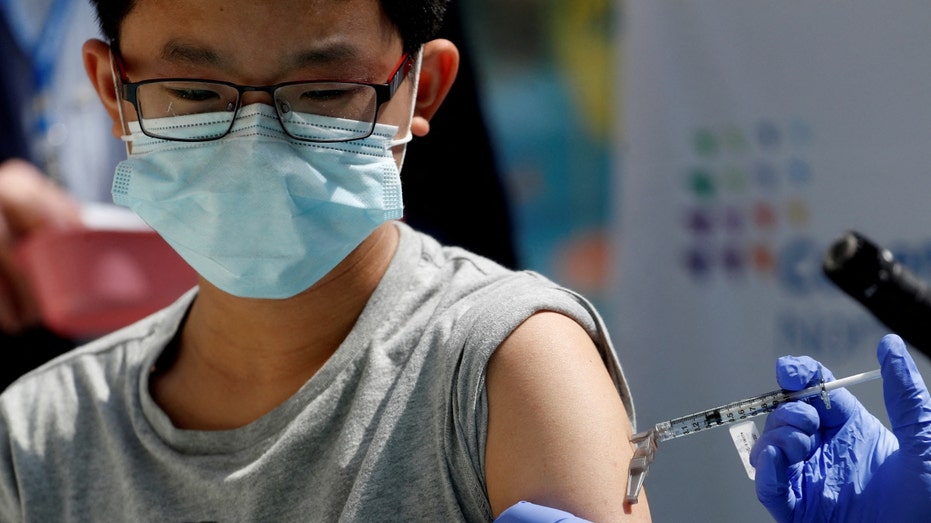 A 13-year-old boy receives a dose of the Pfizer vaccine