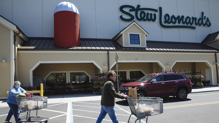 Customers push shopping carts outside a Stew Leonard's supermarket in Paramus, New Jersey, on Tuesday, May 12, 2020. 