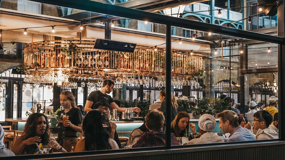 View through the window of staff and customers inside Buns and Buns restaurant in Covent Garden Market, London, UK.