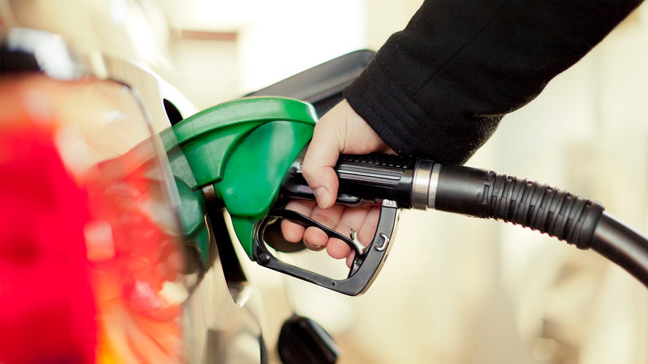 Hand pumps gas into car