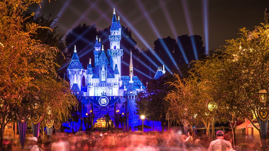 Disneyland 60th aniversary castle with people walking