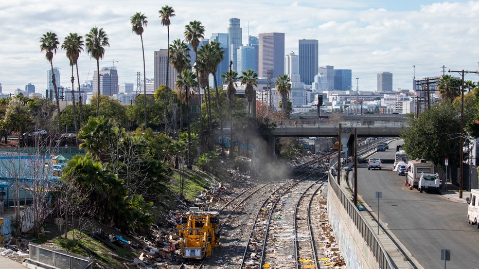 railroad tracks in foreground, LA skyline in background