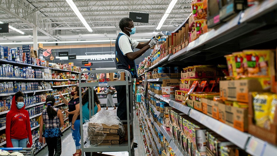 FILE PHOTO: A worker and shoppers are seen wearing masks at a Walmart store, in North Brunswick, New Jersey, U.S. 
