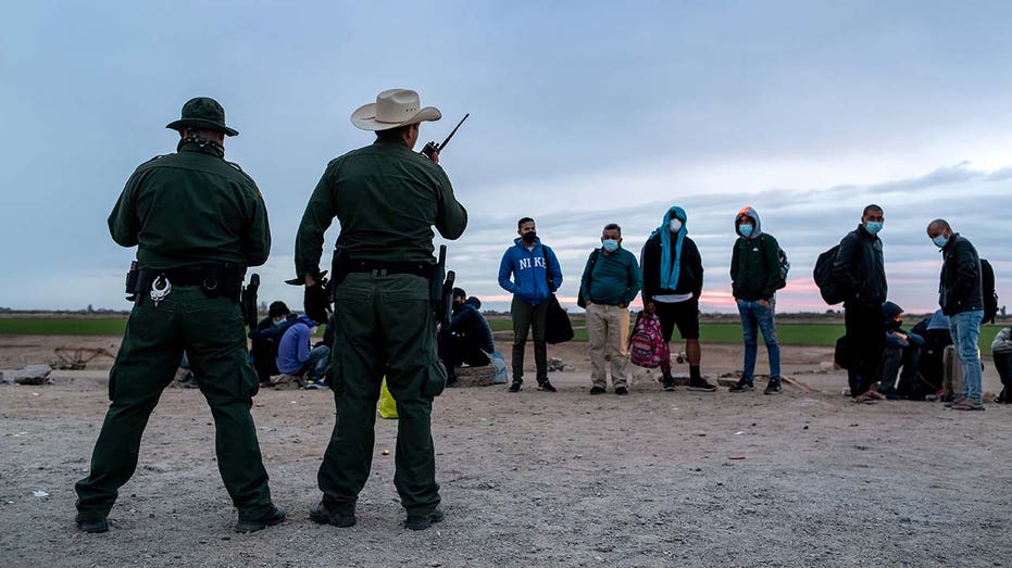 Border Patrol agents with immigrants