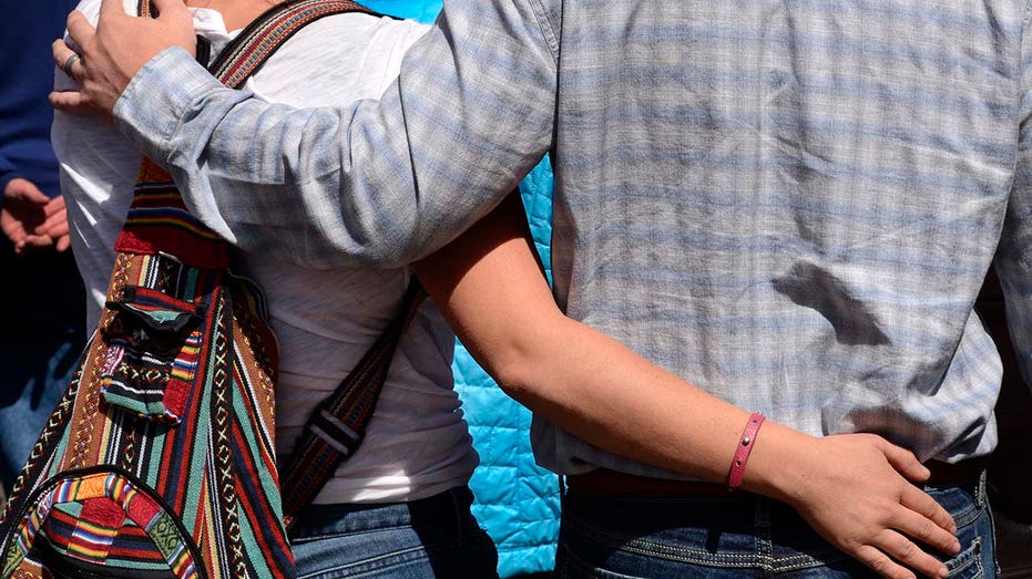 A young couple walk with arms around each other in Santa Fe, New Mexico. 