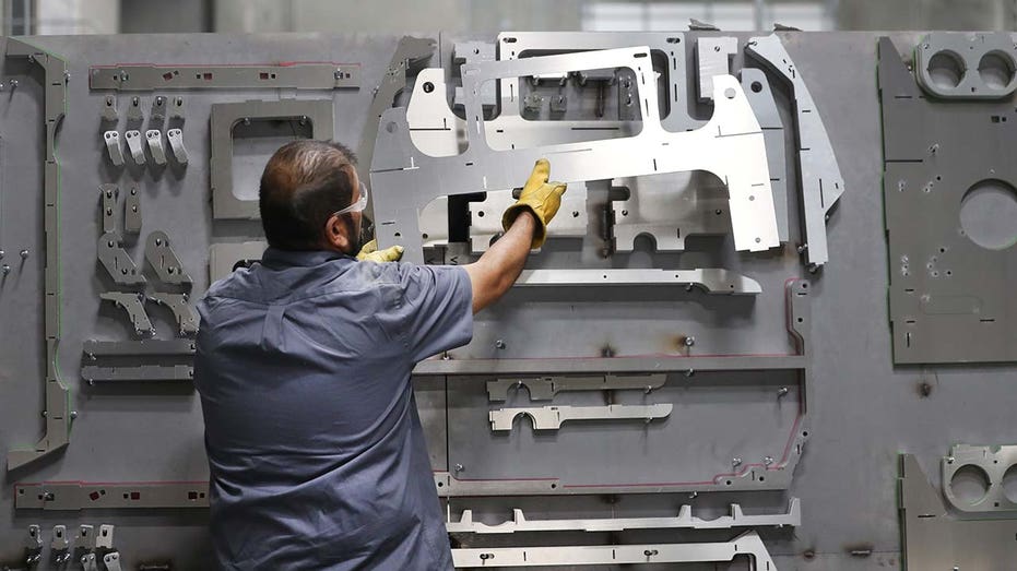 A worker hangs parts on a wall to be used in a Venice model roadster vehicle at the Vanderhall Motor Works Inc. manufacturing facility in Provo, Utah. 