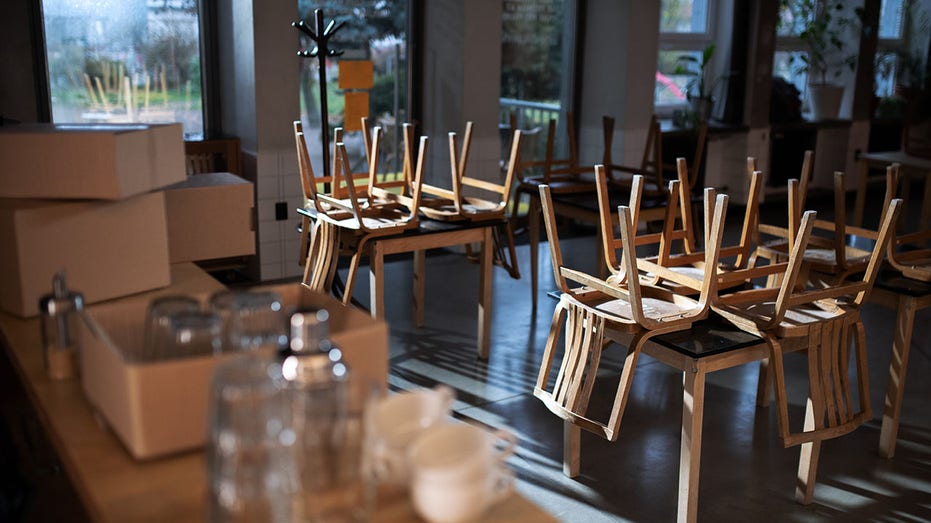 stock image of a closed cafe with chairs on table 