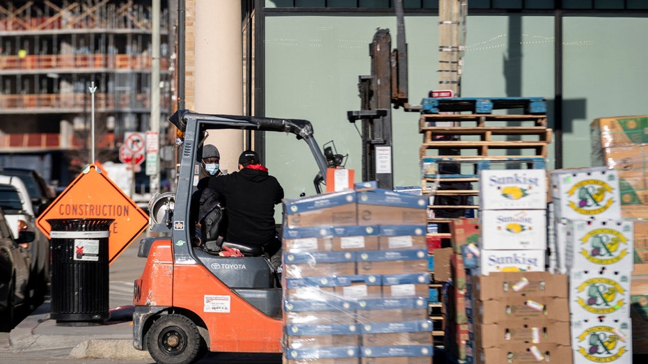 Workers unload shipments of food at Union Market in Washington, D.C., on Feb. 9, 2022. 