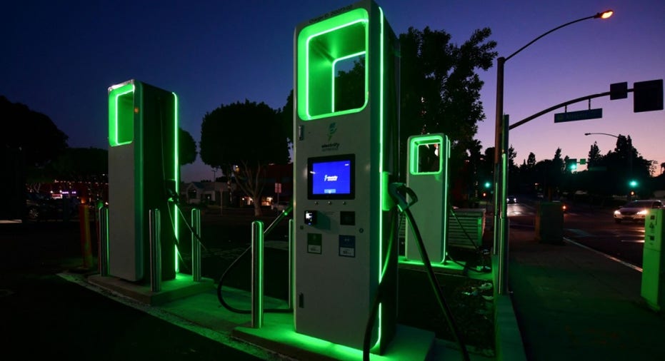 Electric vehicle charging station glowing with green lights