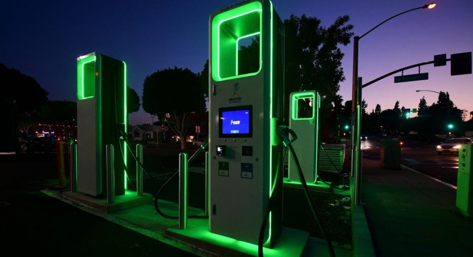 Electric vehicle charging station glowing with green lights