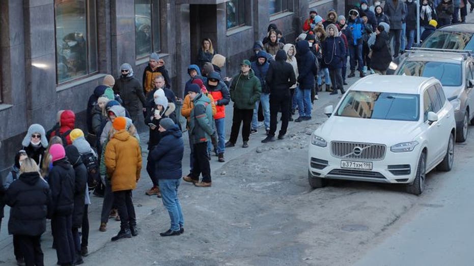 Customers line up outside a bank