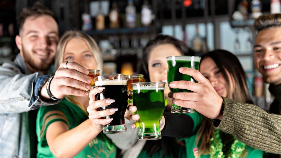 People holding up green beer