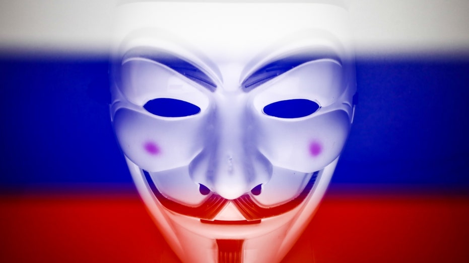 Rosyjska flaga i maska ​​Guya Fawkesa wyświetlane na ekranie laptopa można zobaczyć na tym wielokrotnym zdjęciu ilustracyjnym wykonanym 1 marca 2022 r. w Krakowie.  Globalna grupa hakerów Anonymous ogłosiła „cyberwojnę” Rosji.  (fot. Jakub Porzycki/NurPhoto via Getty Images)